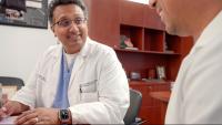 Dr. Sahil Parikh sitting at table with doctor discussing a procedure