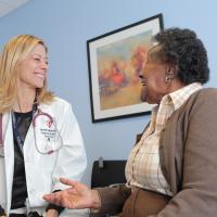 Female physician smiling with elderly patient.
